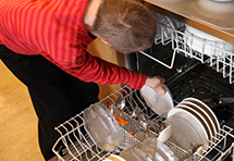 Apua arjessa: henkilö laittaa astioita astianpesukoneeseen. Kuva: Maarit Miettinen